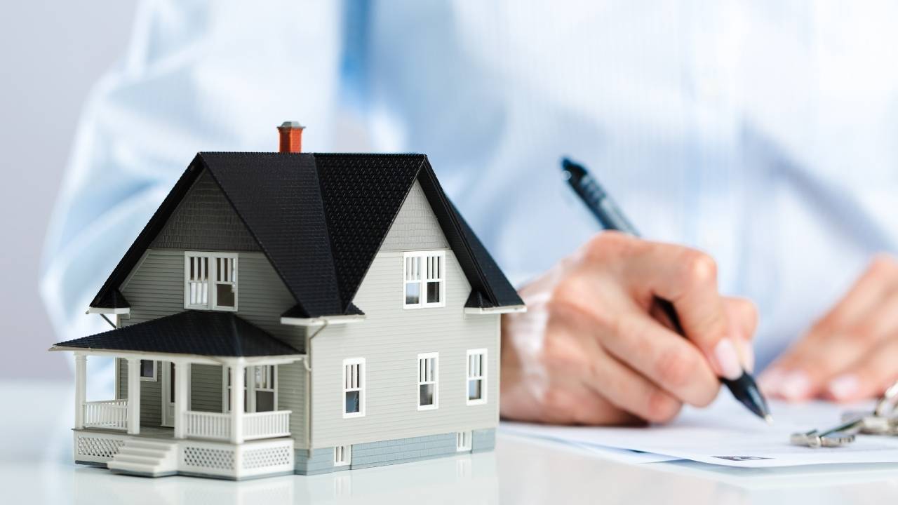 person%20writing%20with%20a%20small%20house%20figurine%20next%20to%20them person%20writing%20with%20a%20small%20house%20figurine%20next%20to%20them